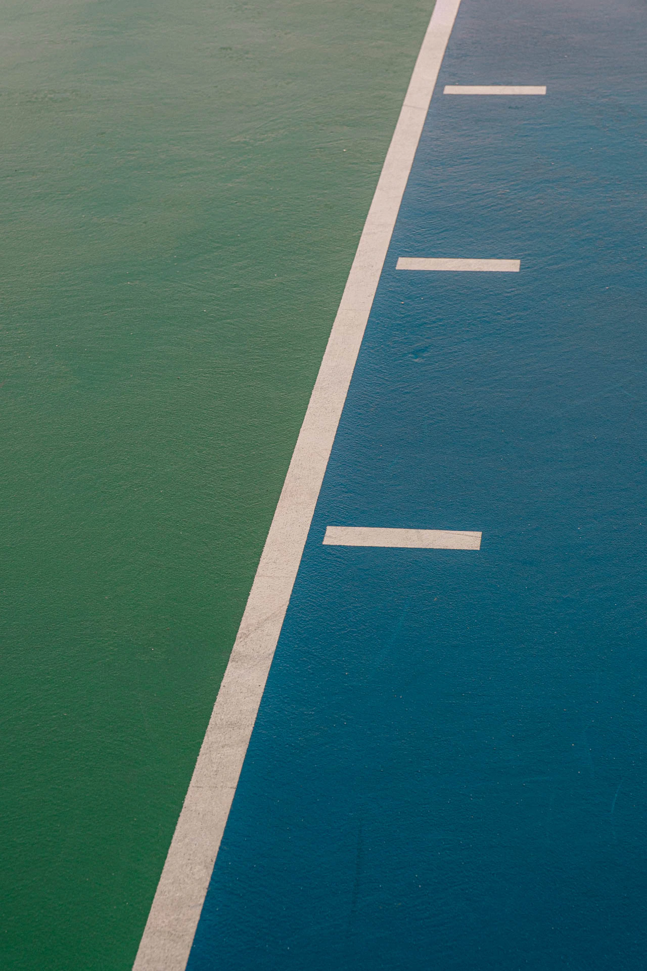 paint lines on a blue and green basketball court after a storm