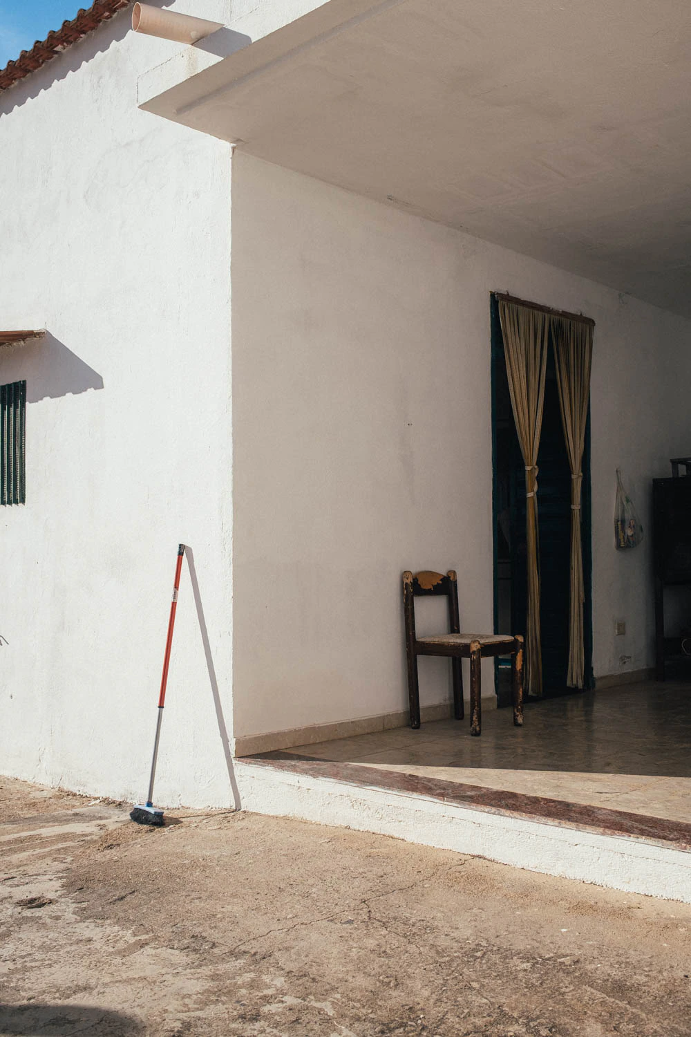 broom leaning on the side of a house