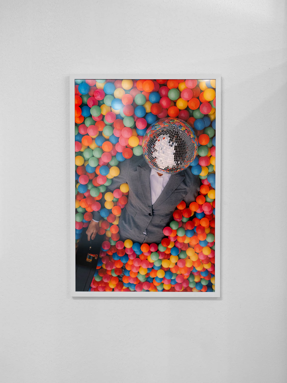 framed photo from happy hour series at sxsw 2025. Man with disco ball head in a colorful ball pit