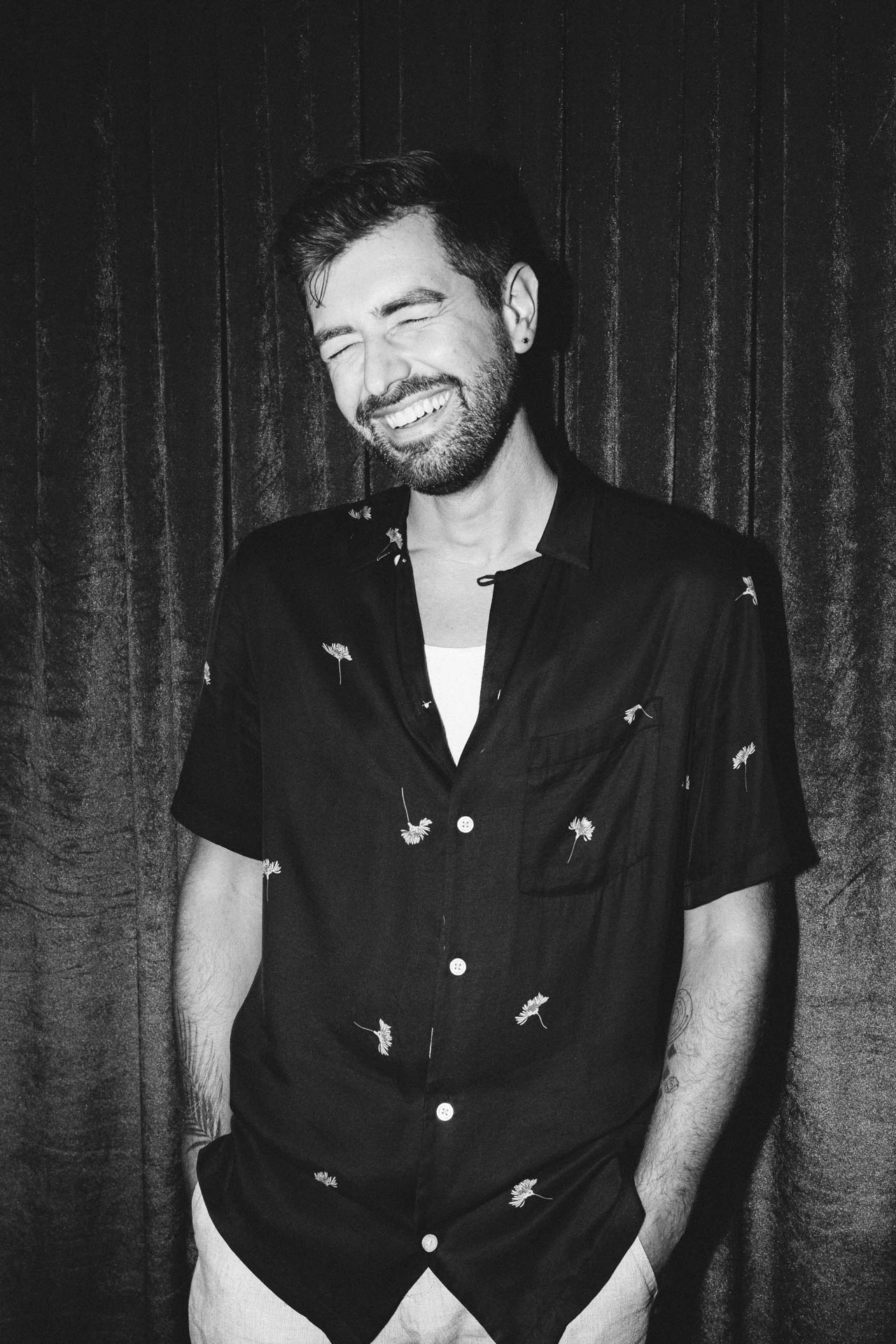Portrait of Jonathan Grado laughing using heightened look flash photography. Black and white velvet.