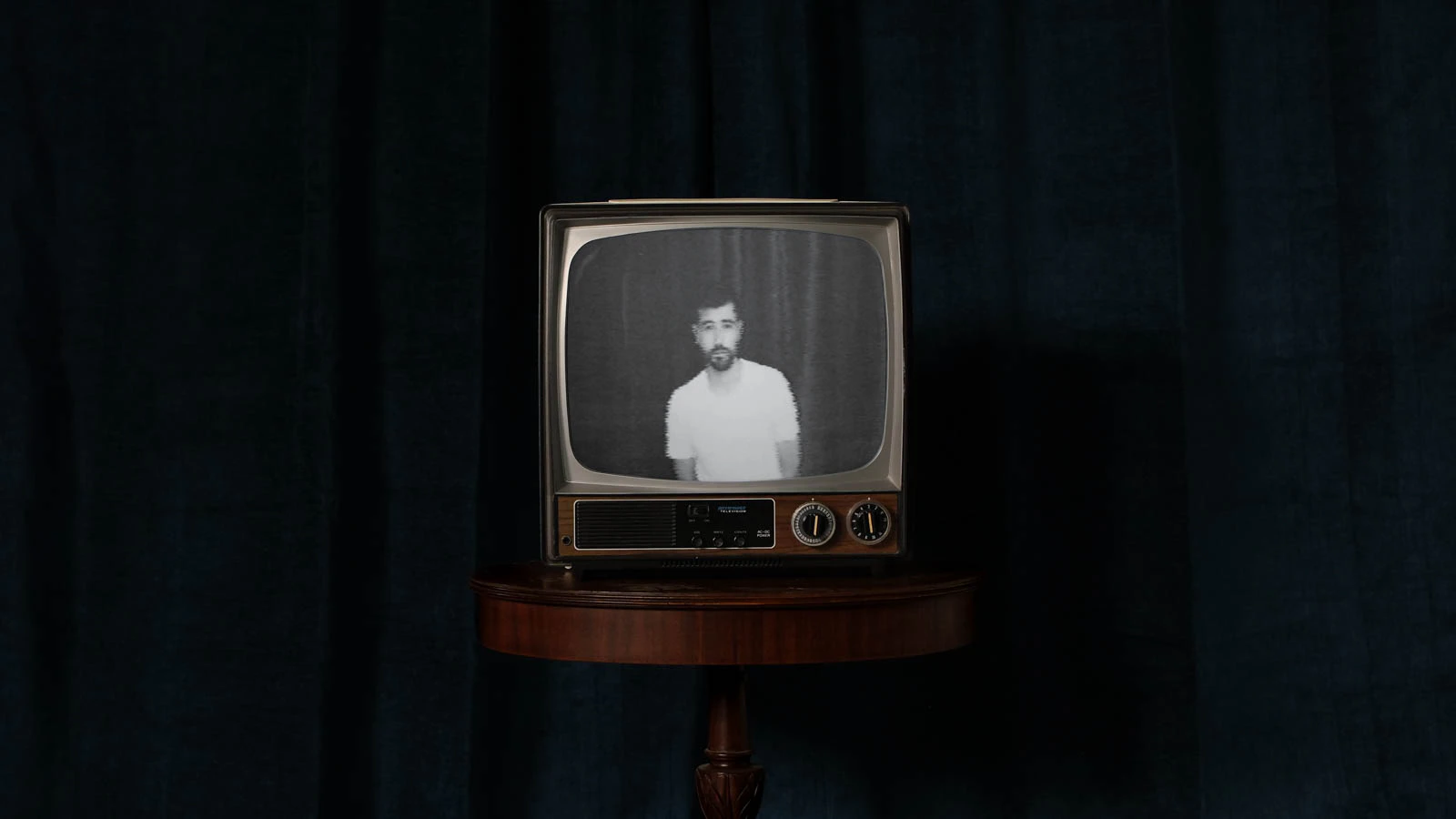 Old TV in front of blue velvet with Jonathan Grado self-portrait on screen. For Overthinking video.