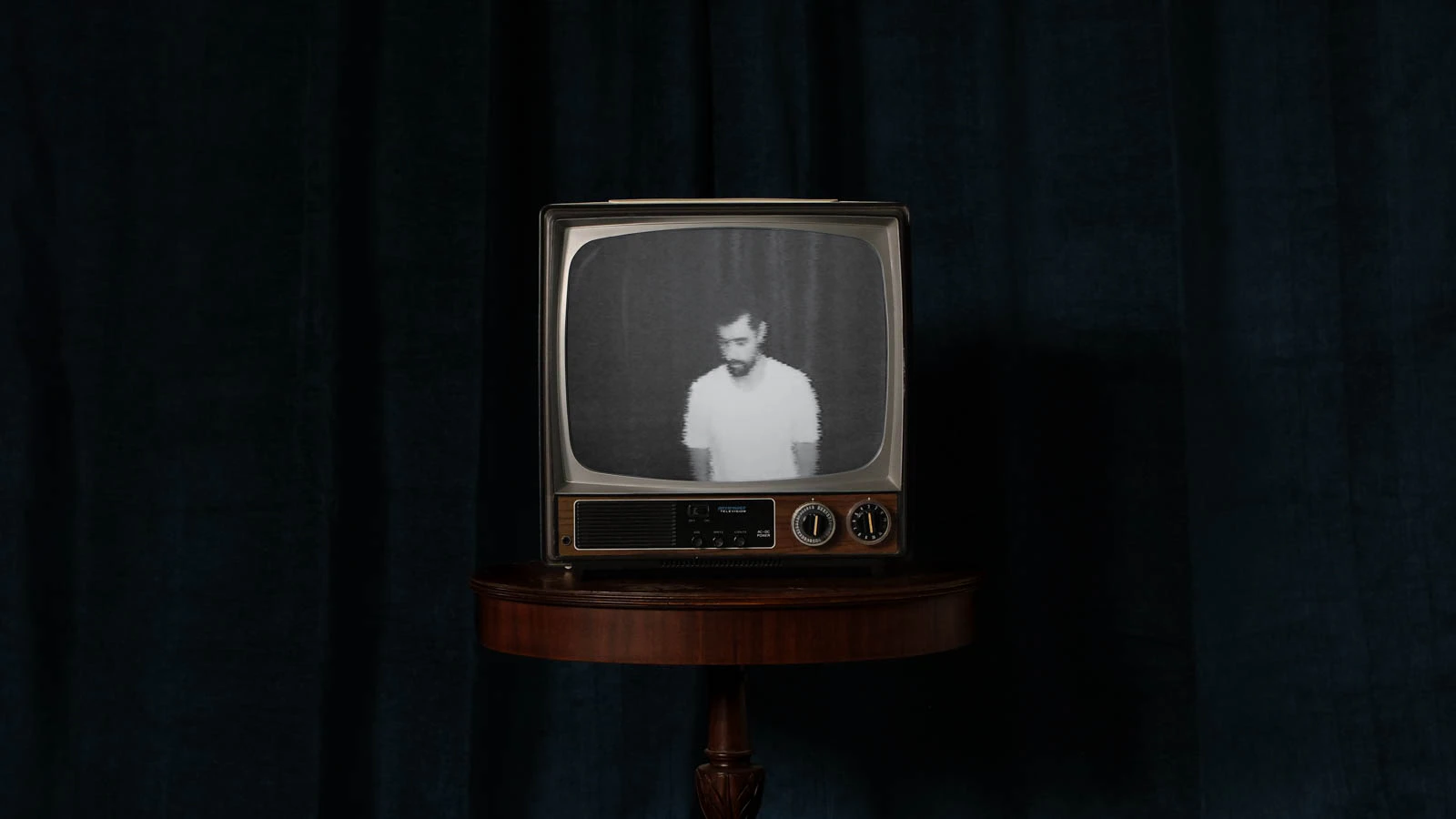 Old TV in front of blue velvet with Jonathan Grado self-portrait on screen. For Overthinking video.