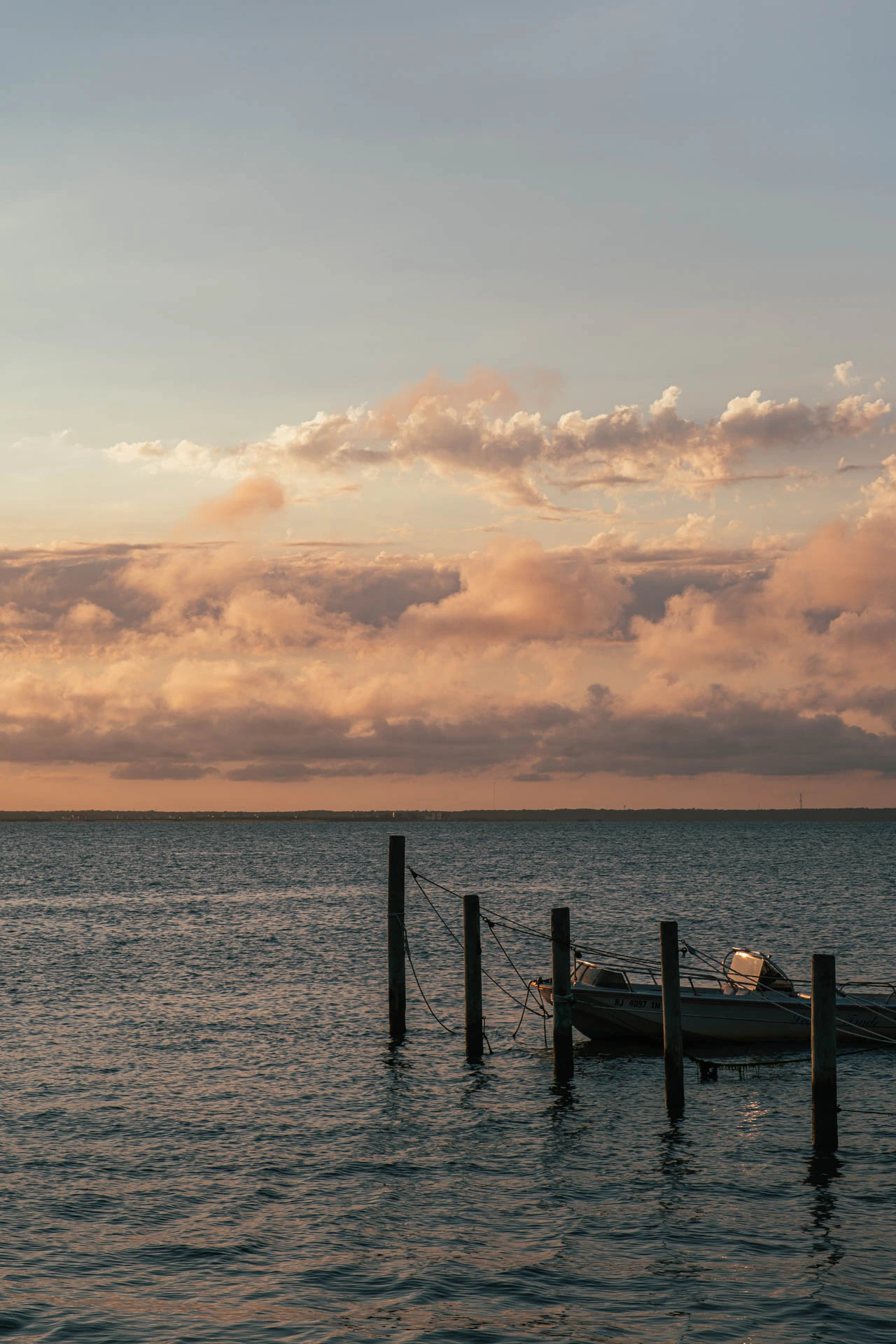 dock and boat one the bay at sunset