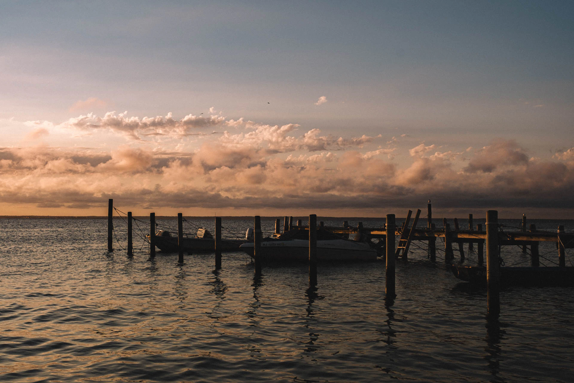 dock and boat one the bay at sunset