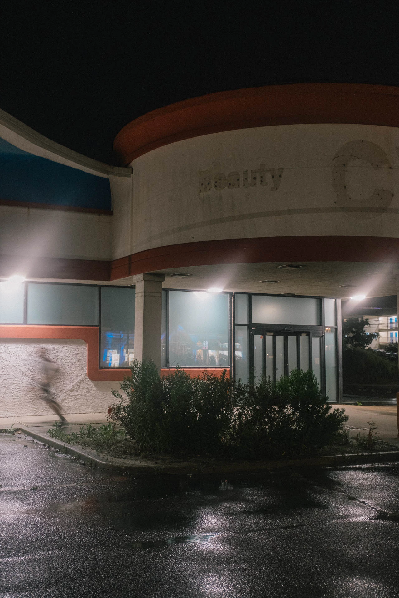 man running in front of a closed CVS at night in Long Beach island