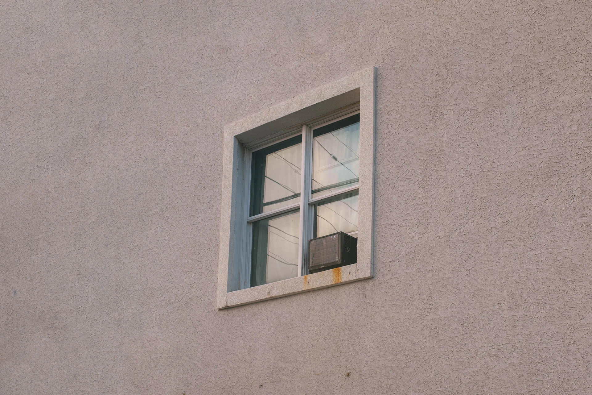 window with air conditioning unit at sunset