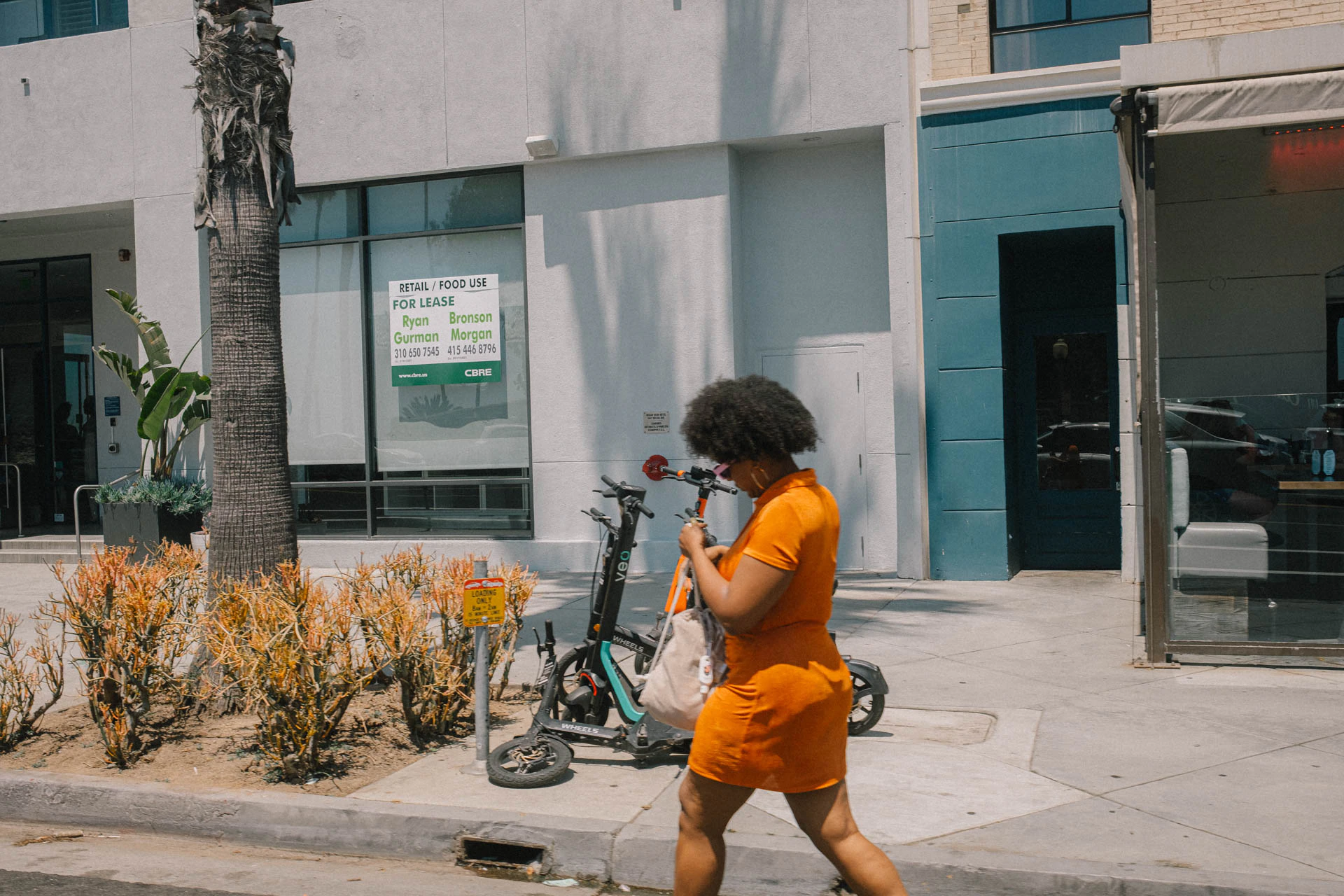 woman in orange crossing the street in Santa Monica