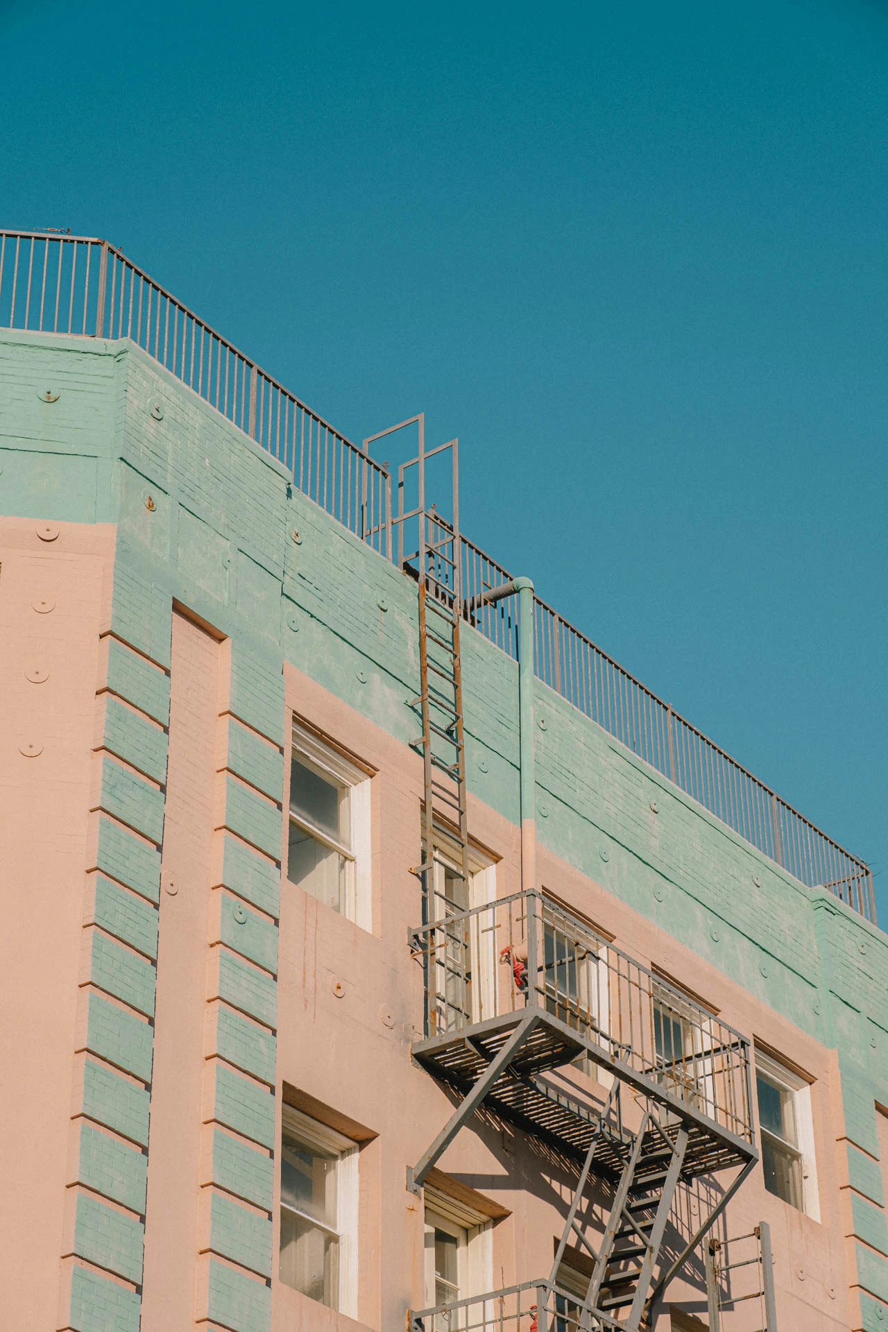 pastel green and pink building with fire escape in Venice Beach