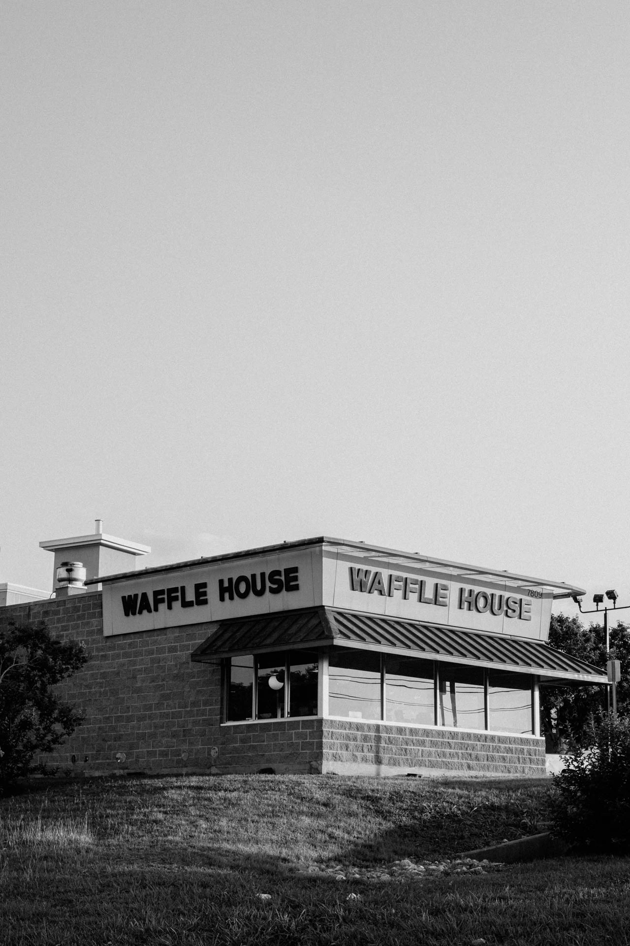 Waffle House at Sunset on a grassy hill in Texas. Black and white.