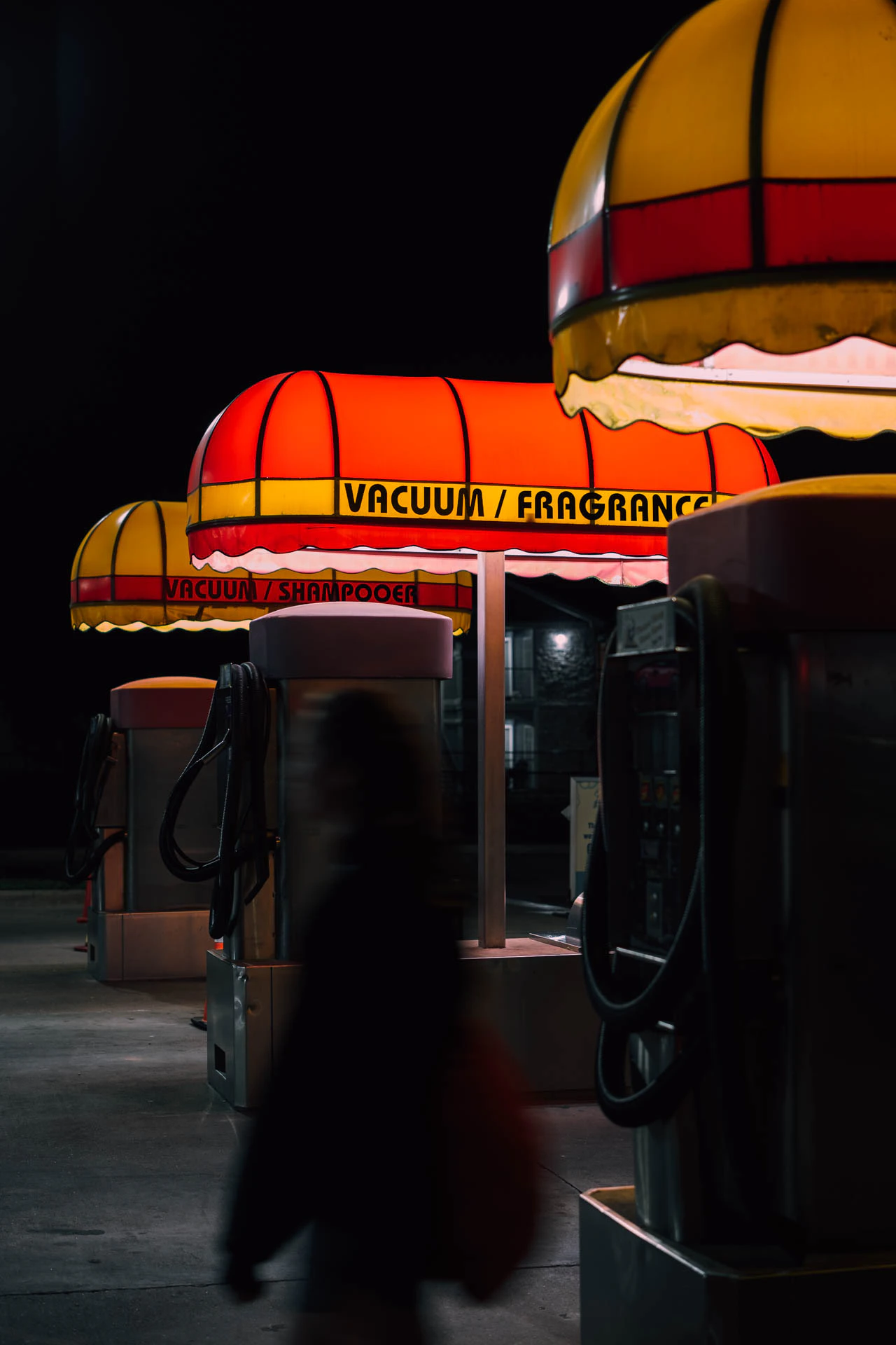 retro car wash with yellow and red awnings reading vacuum fragrance at night