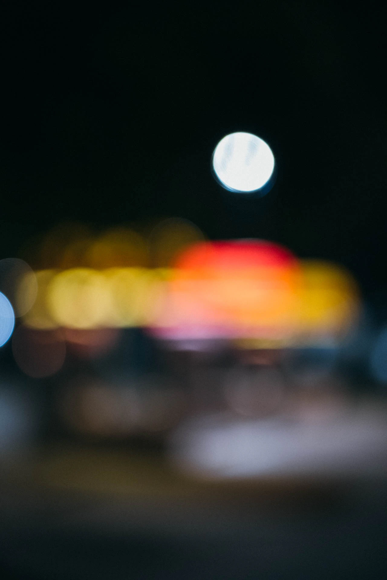 out of focus retro car wash with yellow and red awnings at night