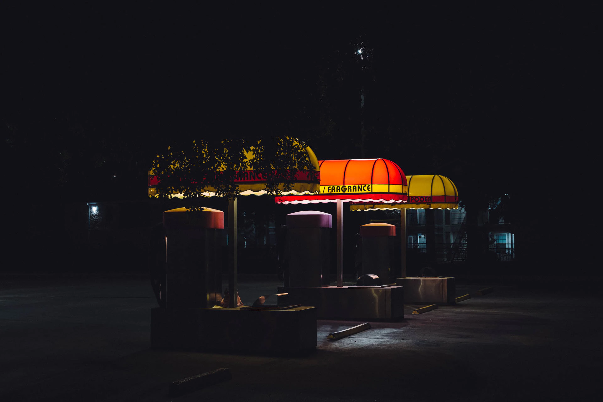 retro car wash with yellow and red awnings reading vacuum fragrance at night