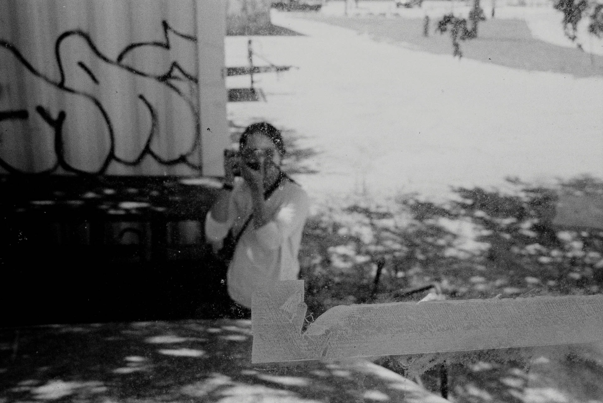 man through glass on black and white film in San Marcos