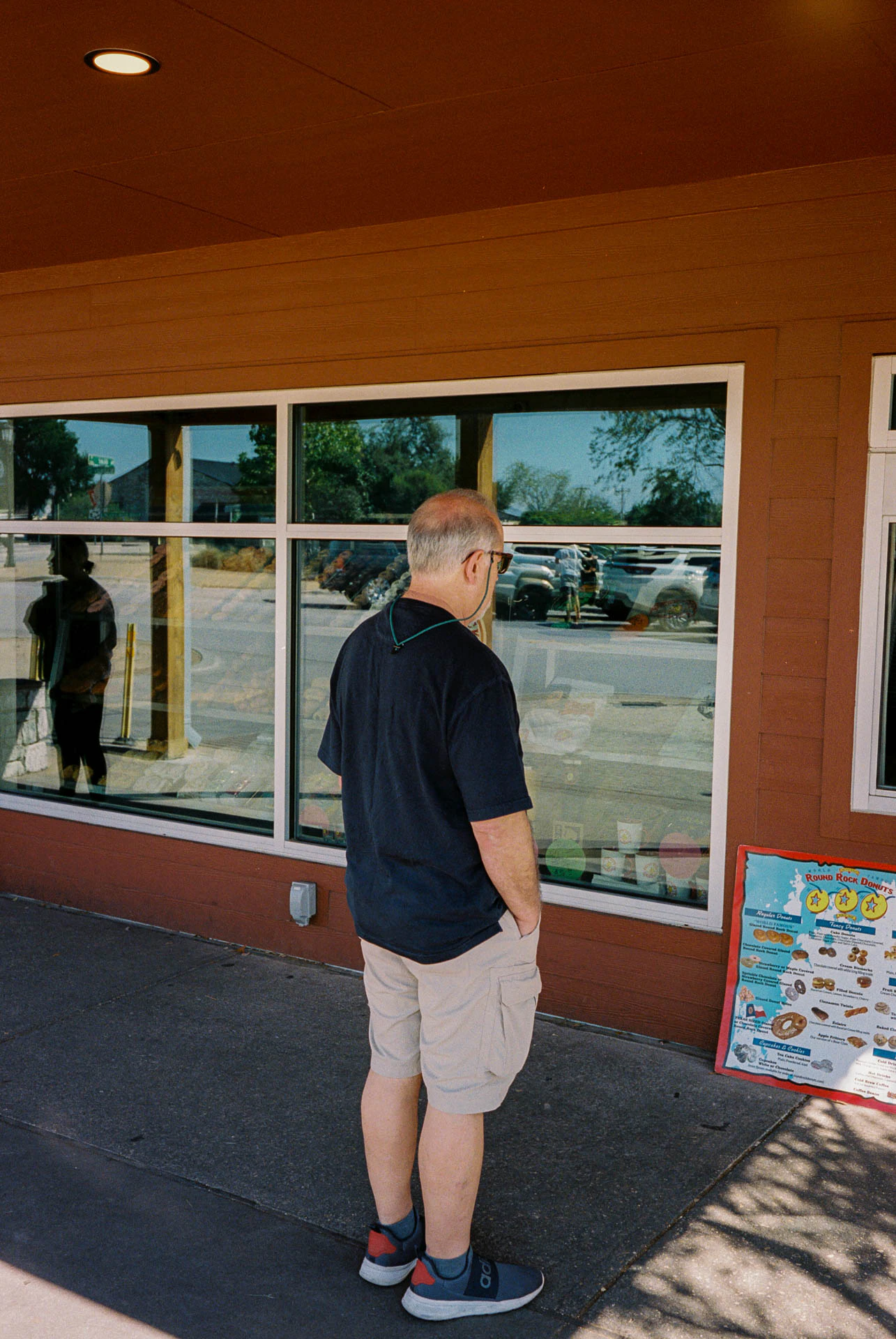 man at round rock donuts on film