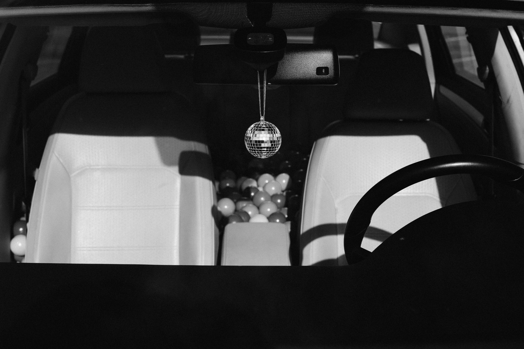 the interior of a car with a hanging disco ball ornament