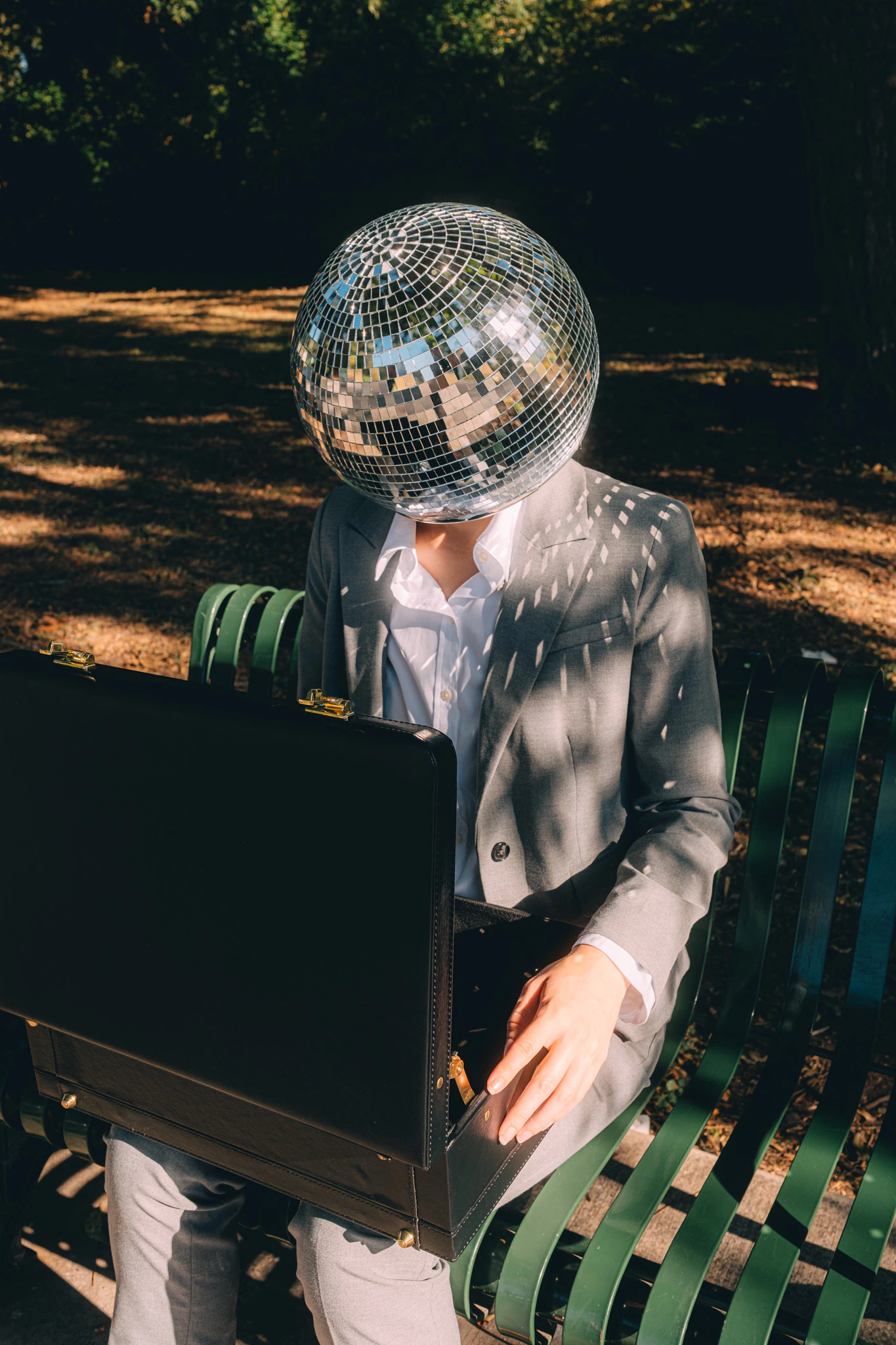 A person in a suit with disco ball for a head looking into their briefcase. Billable Hours from Jonathan Grado's Happy Hour series.