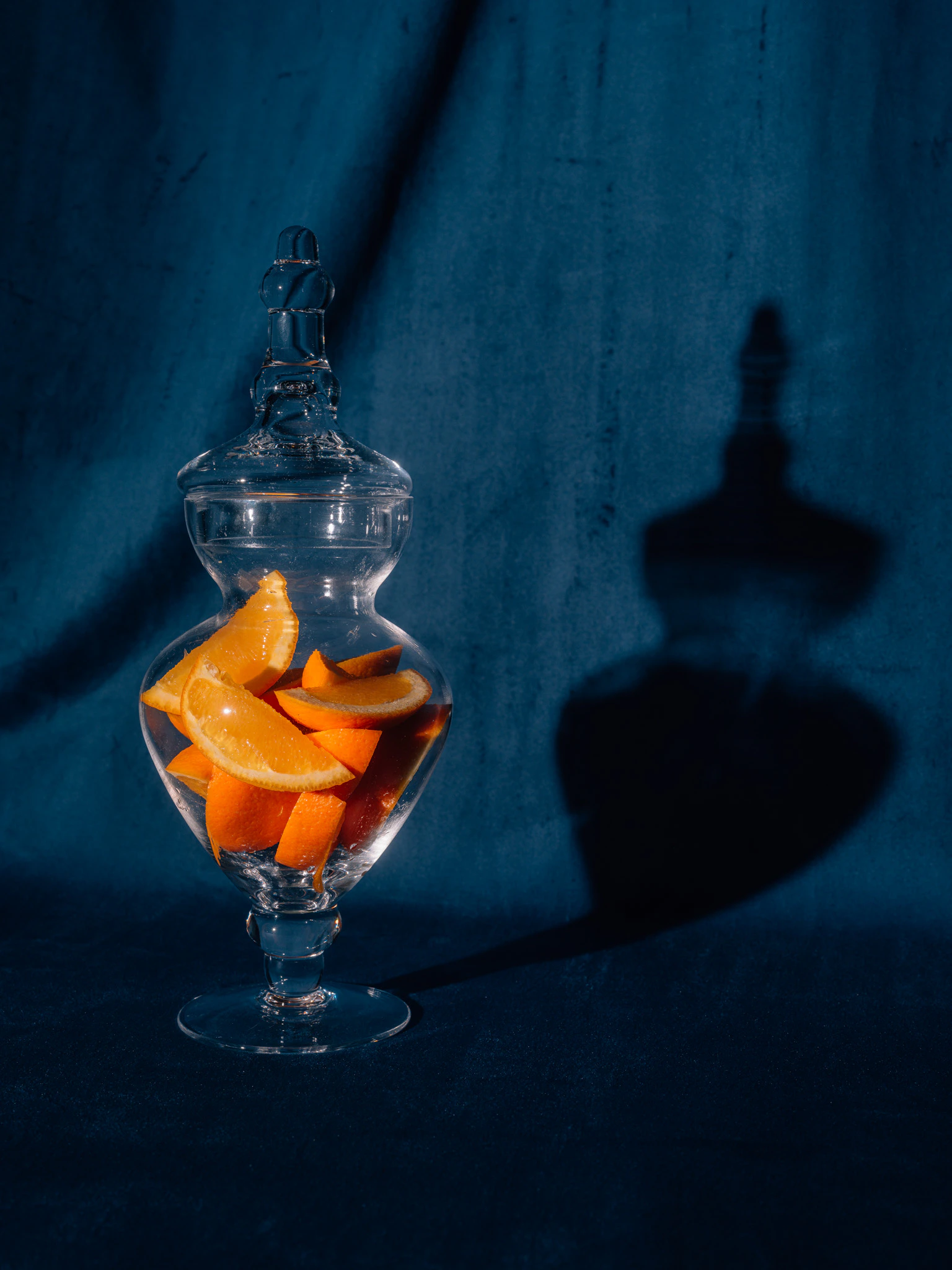 Orange slices in a candy jar on blue velvet. The Trouble with Archiving from Jonathan Grado's Saint Citrus series.