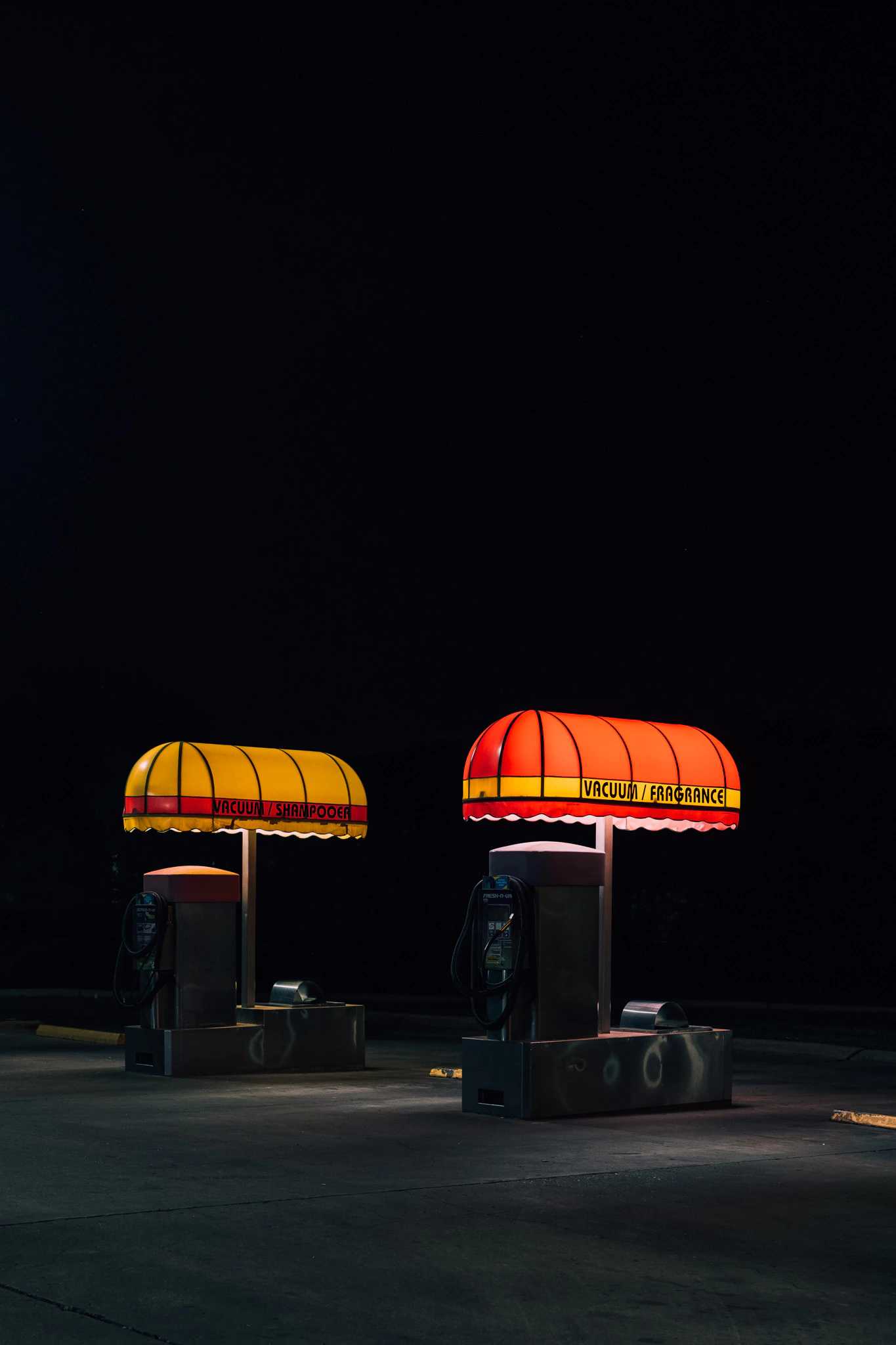 Two vacuum and fragrance stations at a retro car wash at night. Vacuum Fragrance #03 from Jonathan Grado's Provided You're Still Here series.