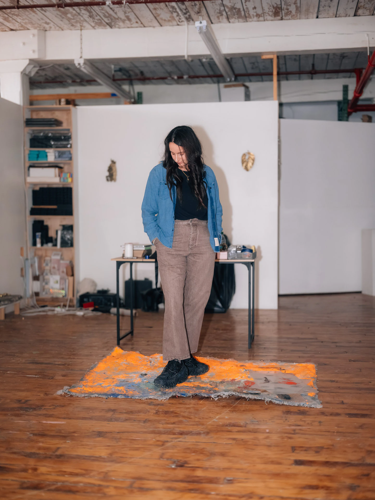 Lara Saget standing on orange rug in her Brooklyn studio
