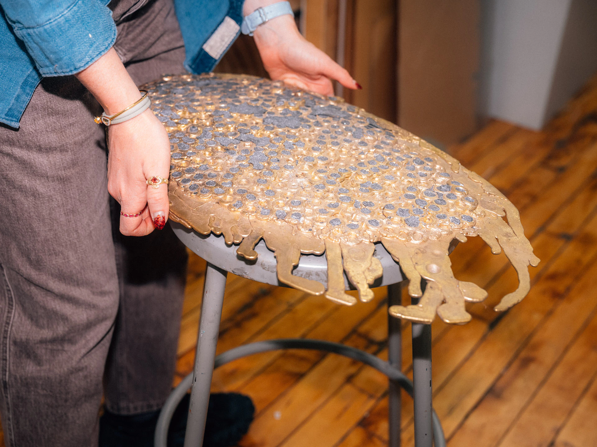 holding bronze work in Lara Saget studio