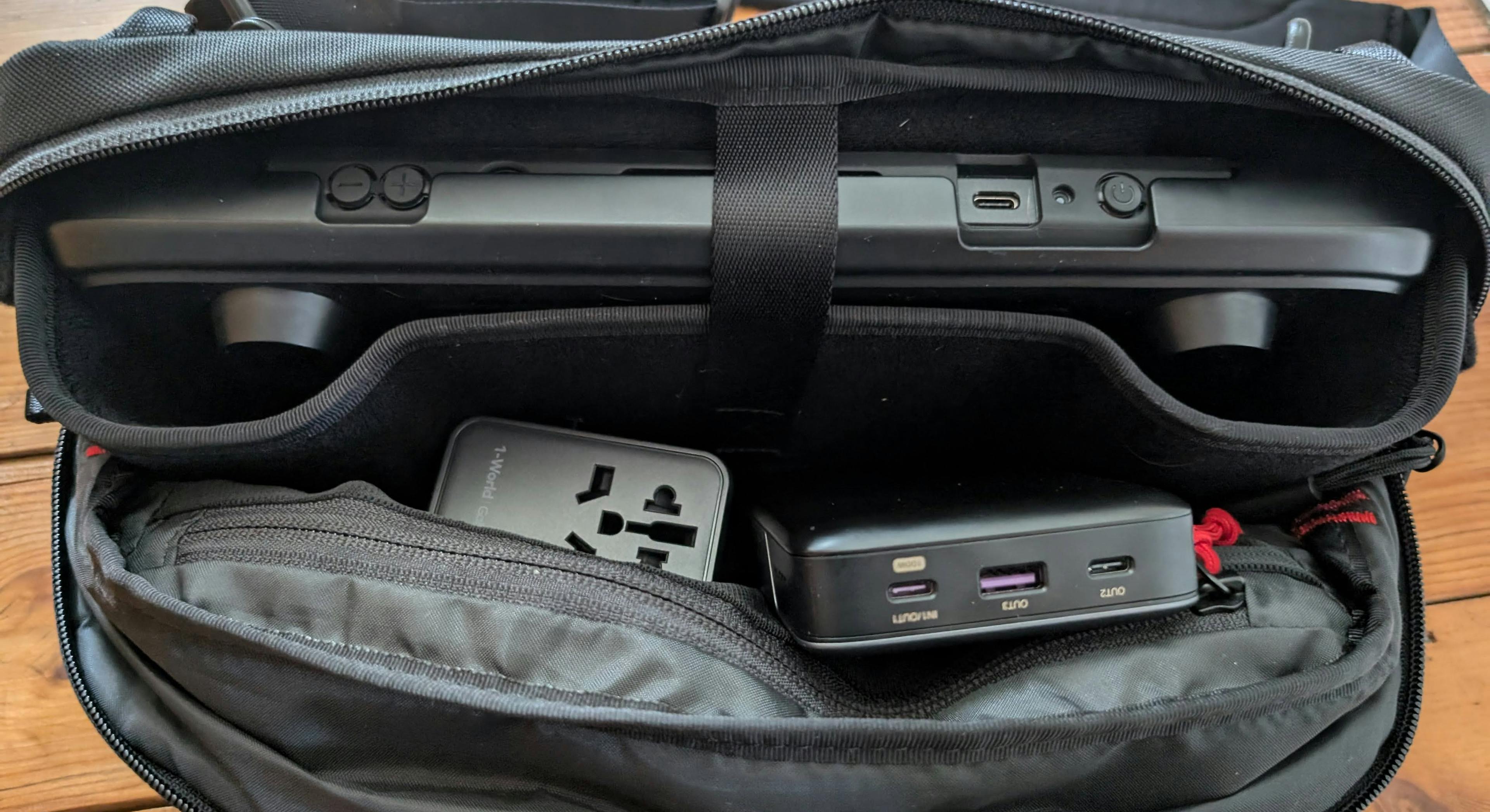 The TomToc bag opened, showing the charger, battery and Steam Deck