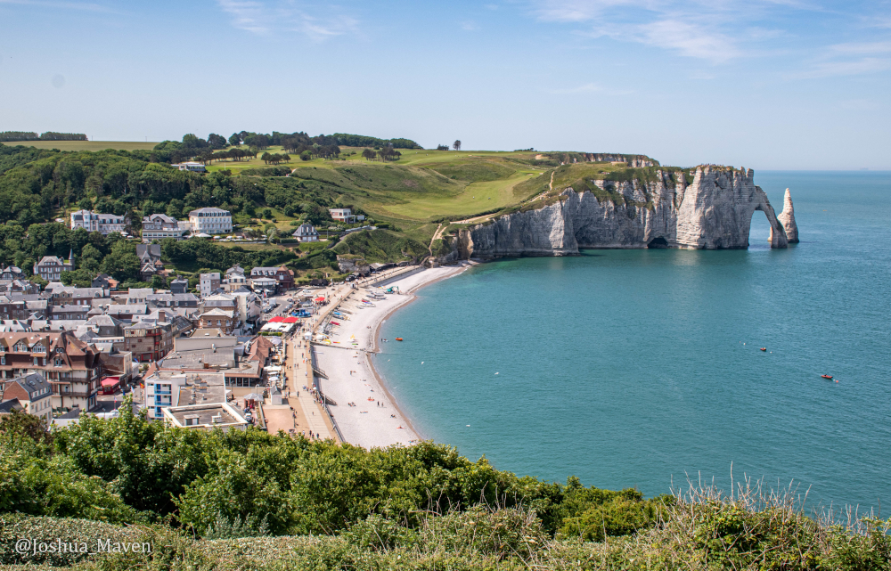 The chalk cliffs of Etretat with the arch known as the Porte d'Aval and the L'Aiguille, or the Needle, in the distance.