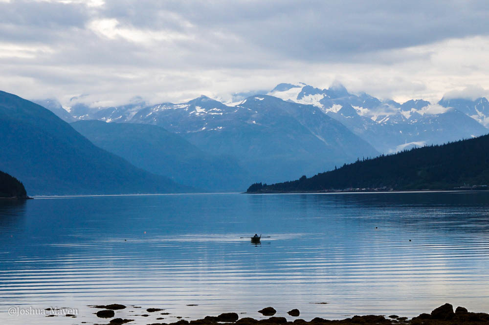 A solo skiff traveling along the waters of the Chilkoot Inlet and a good representation of Dteshshuh - the end of the trail.