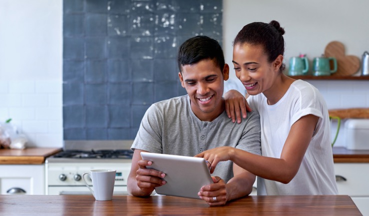 A couple of people looking at a tablet device