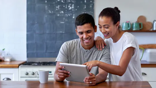 A couple of people looking at a tablet device