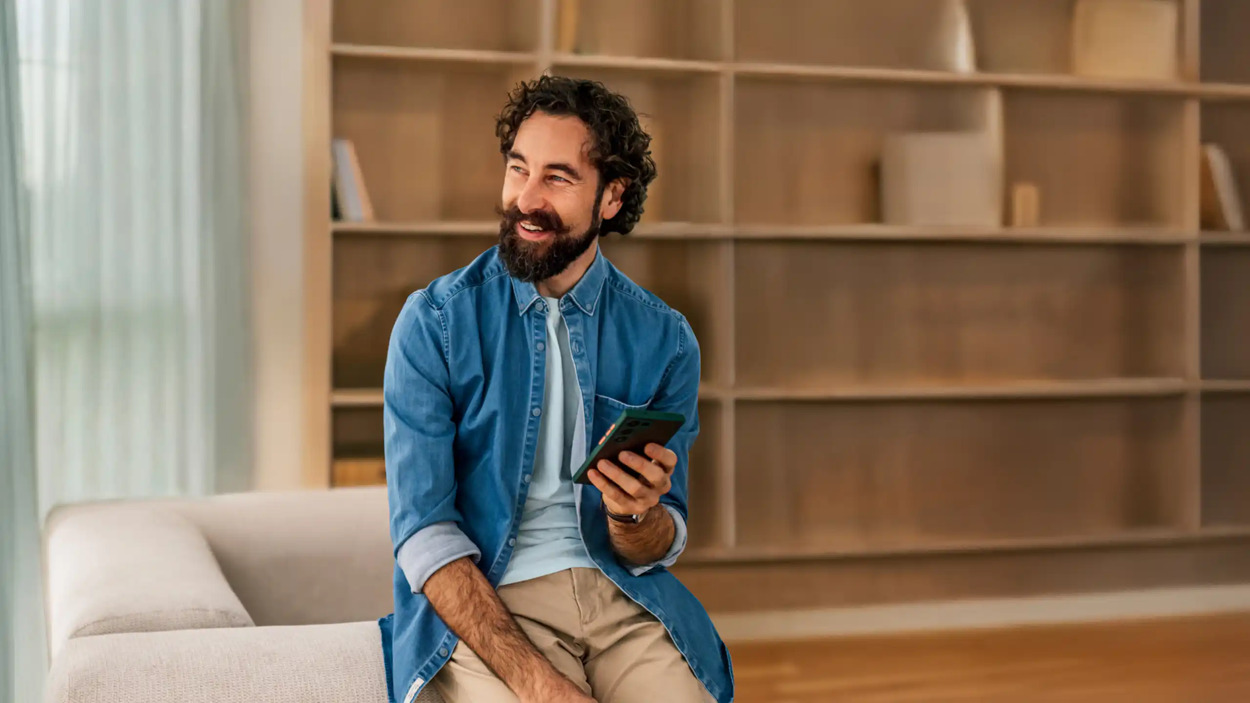 Man sitting down on the sofa smiling