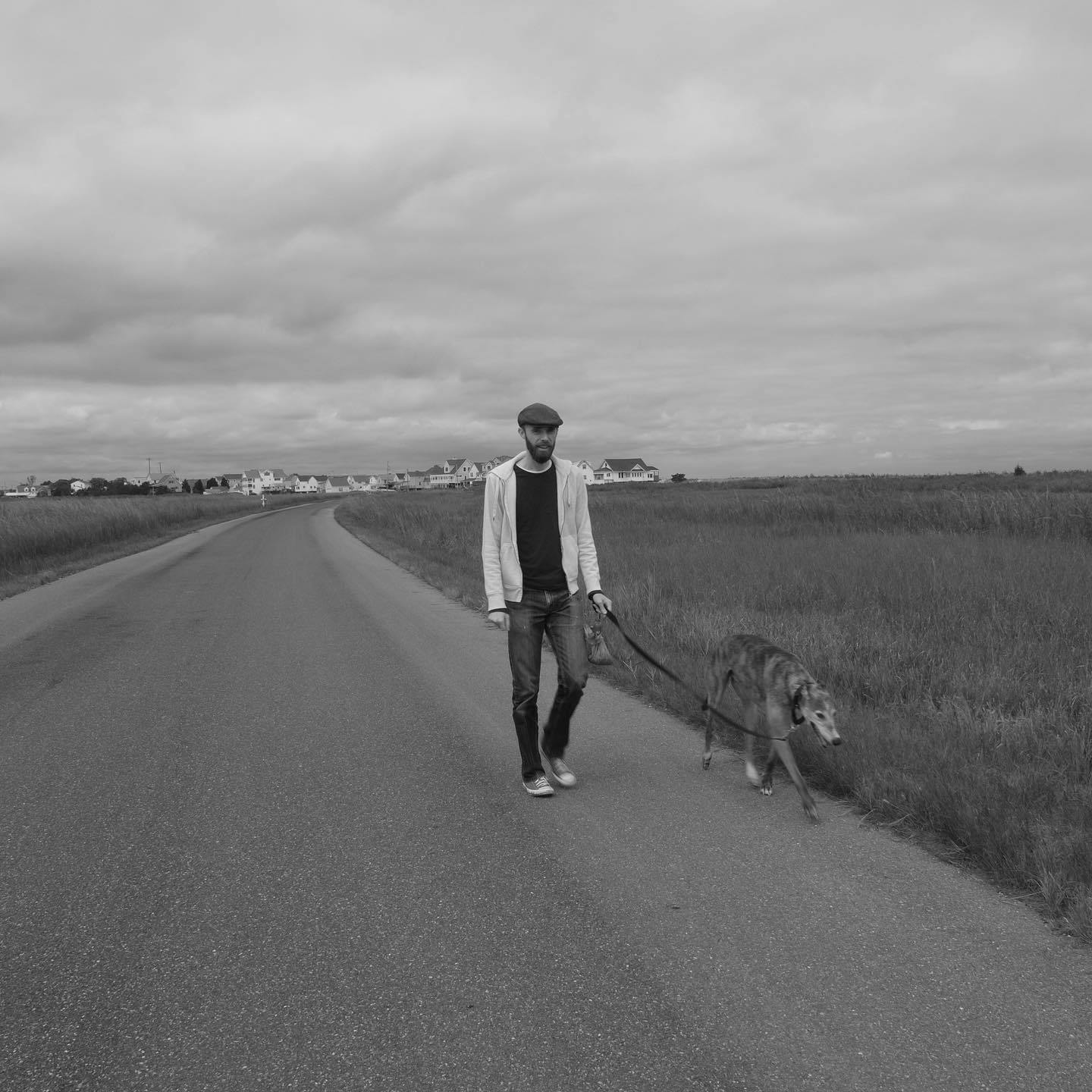 Me, walking with a young Kepler down a road on the Delaware coast. Grassy fields line the road, and a small town is visible in the distance.