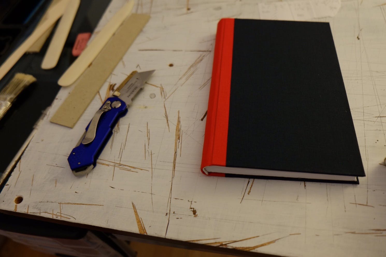 Andy’s new journal, sitting alongside a knife, bone folder, and some scraps of cardboard
