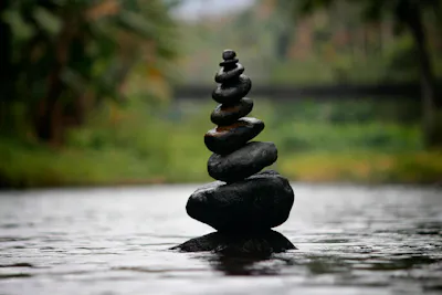 The image shows the balancing of stones or stacking of stones, which is often associated with the concept of Zen. 
