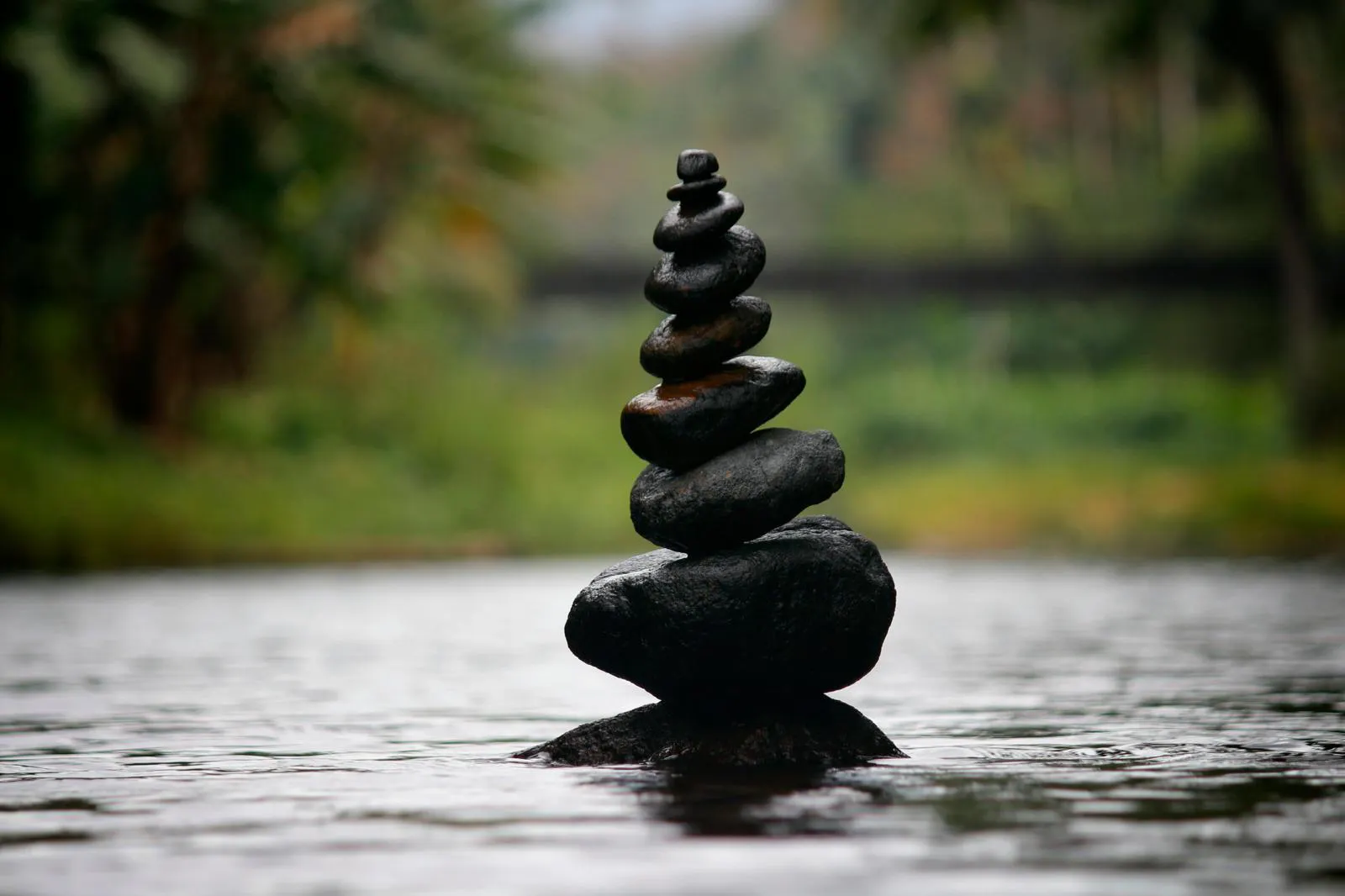 The image shows the balancing of stones or stacking of stones, which is often associated with the concept of Zen.