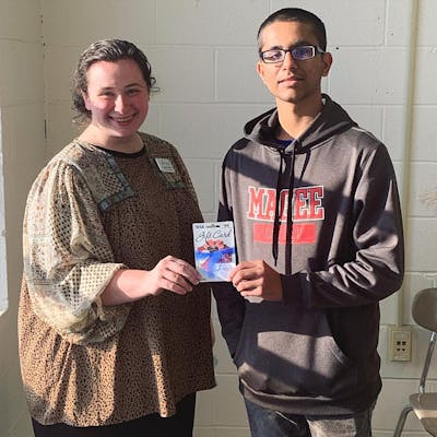 Poojan Patel, a junior at Magee High School, receives an award from Hannah Mason, Jumpstart Test Prep's Operations and Media Coordinator, for achieving a first-attempt score of 20 or higher on the English sub-section of the ACT.