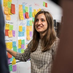 A visual designer standing for a wall with sticky notes