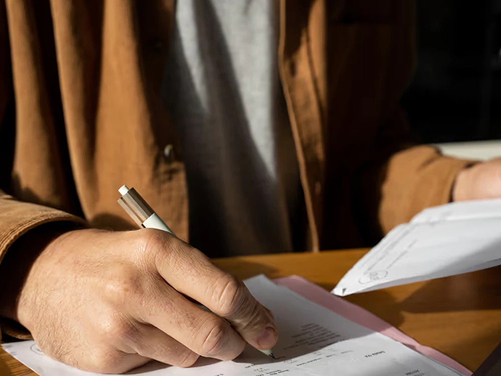 Person skriver på ett pappaer