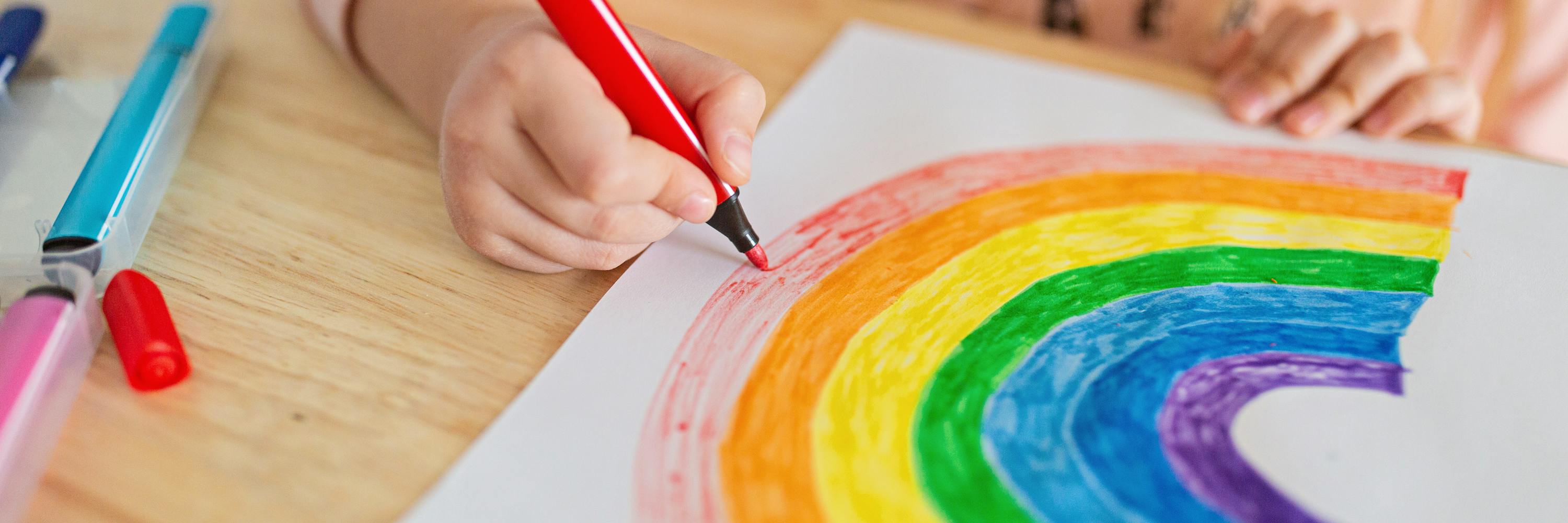 Kind zeichnet einen Regenbogen
