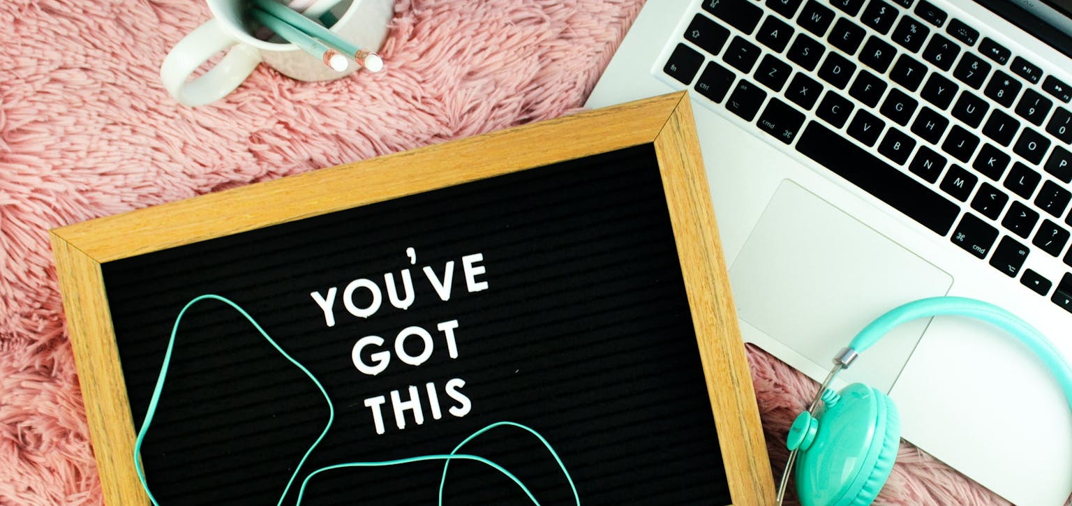 A Laptop, headphones and pencil pot with a chalkboard saying - you've got this.
