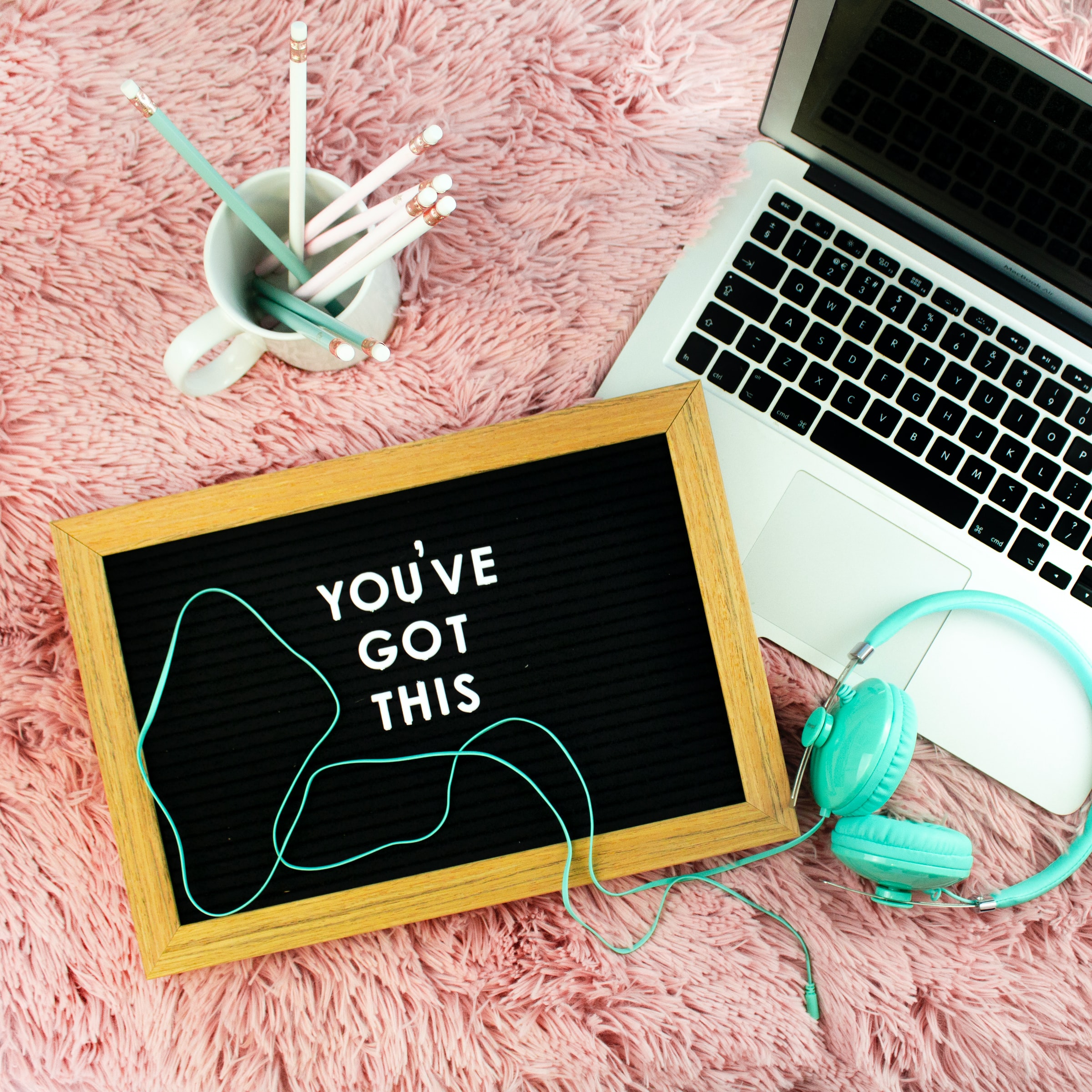 A Laptop, headphones and pencil pot with a chalkboard saying you've got this - a photo by Emma Matthews Digital Content Production
