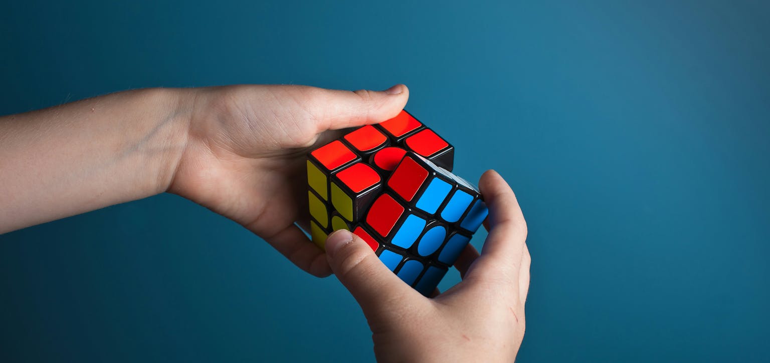 Hands holding a Rubiks cube puzzle