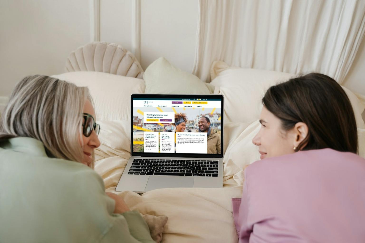 Two people look at Glaucoma UK website on macbook 