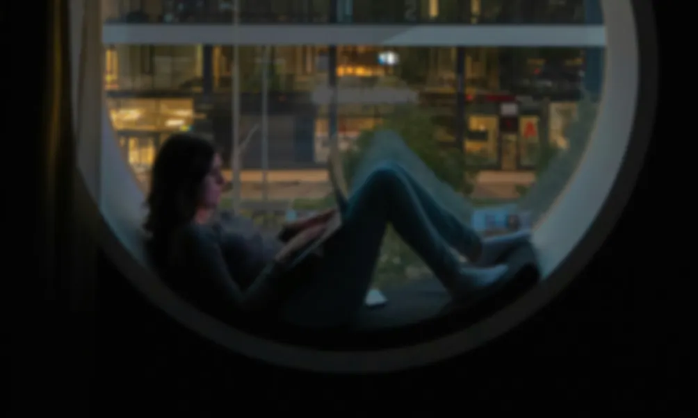 girl with laptop in circular window seat