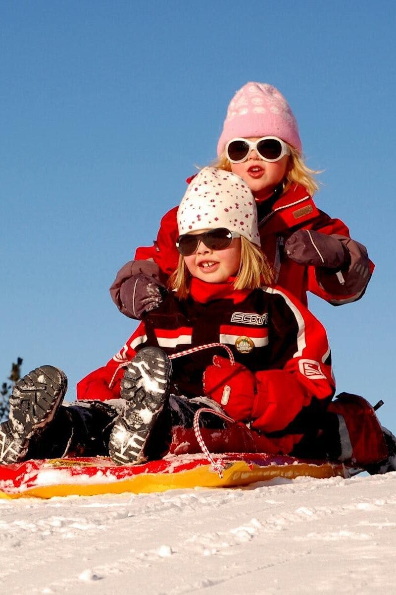 enfants jouant sur une luge à la montagne