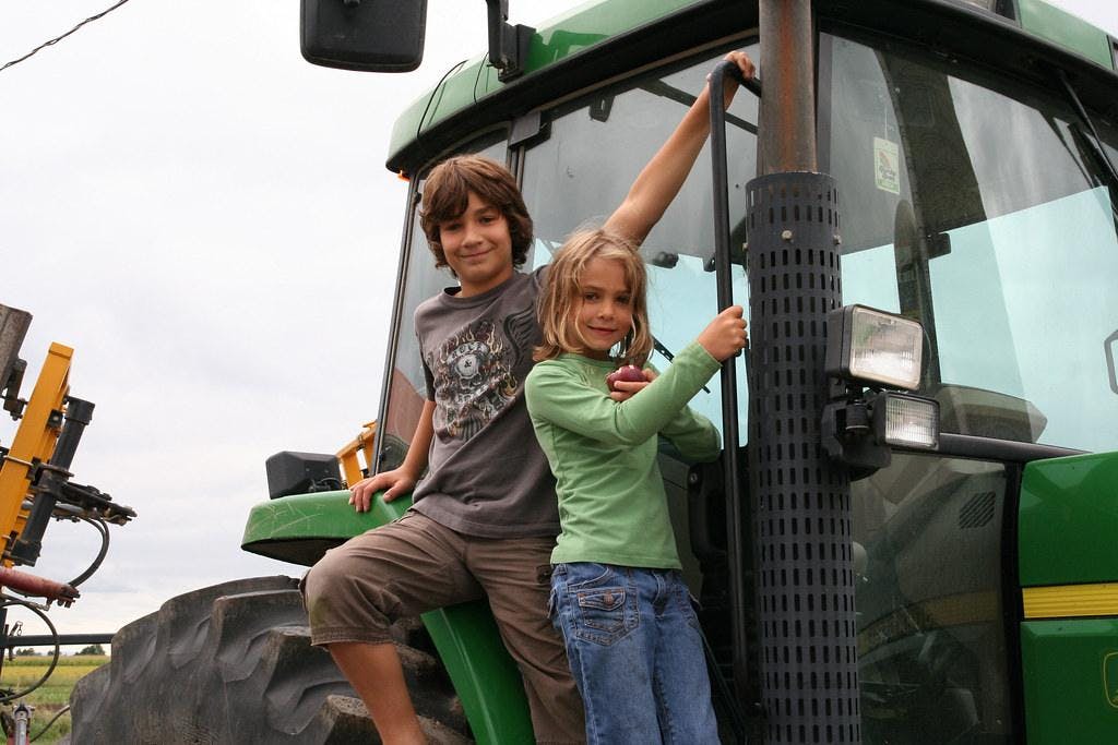 enfants sur un tracteur s'amusant à la ferme