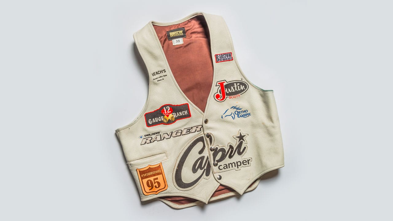 Riding vest with various brand labels.