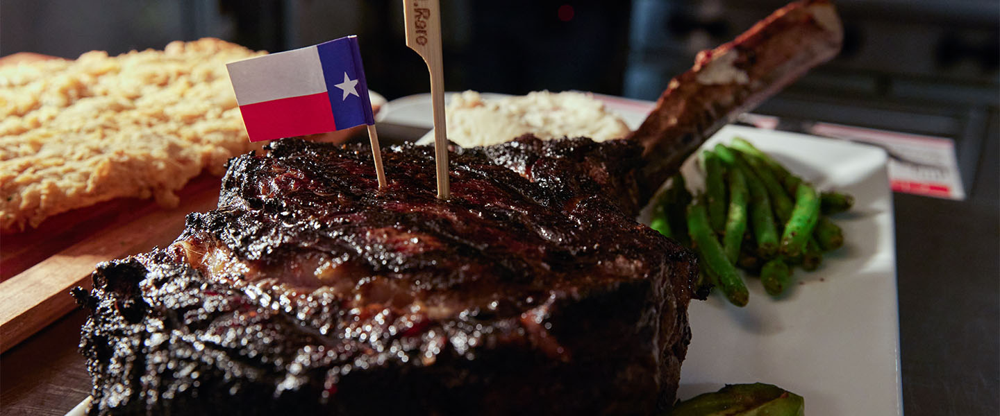 Un filete de chuletón con un palillo de la bandera de Texas clavado en la parte superior.