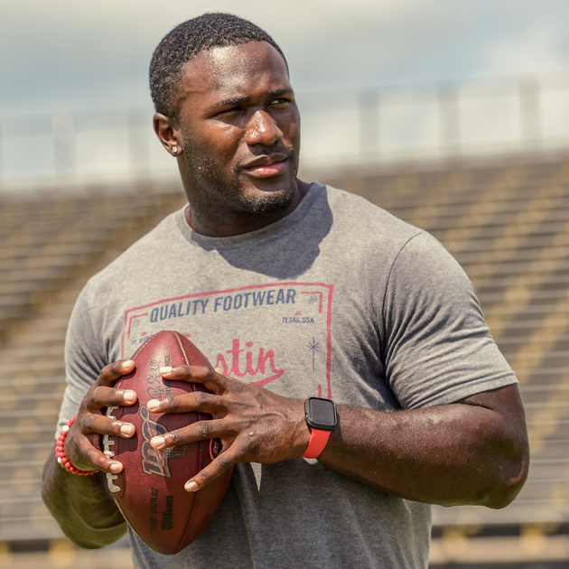 Tampa Bay Buccaneers linebacker Devin White holding a football on his high school field.