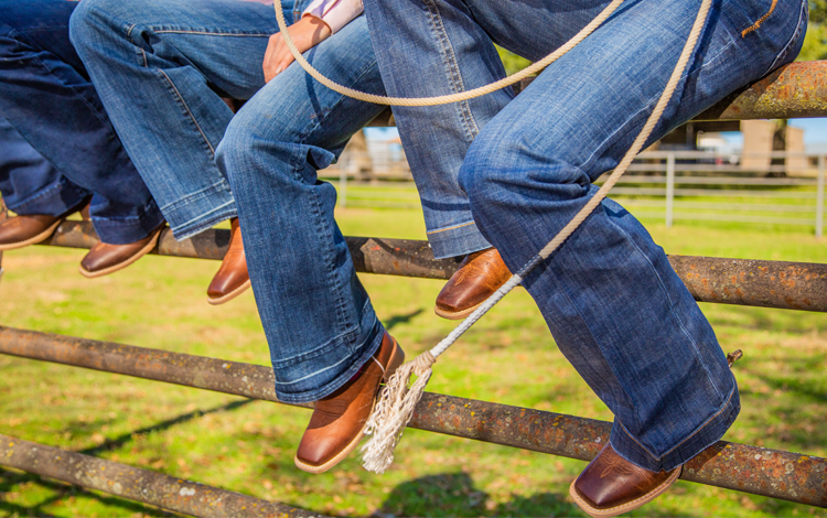 Cowgirls sitting on a fence in their Justin Gypsy® boots.