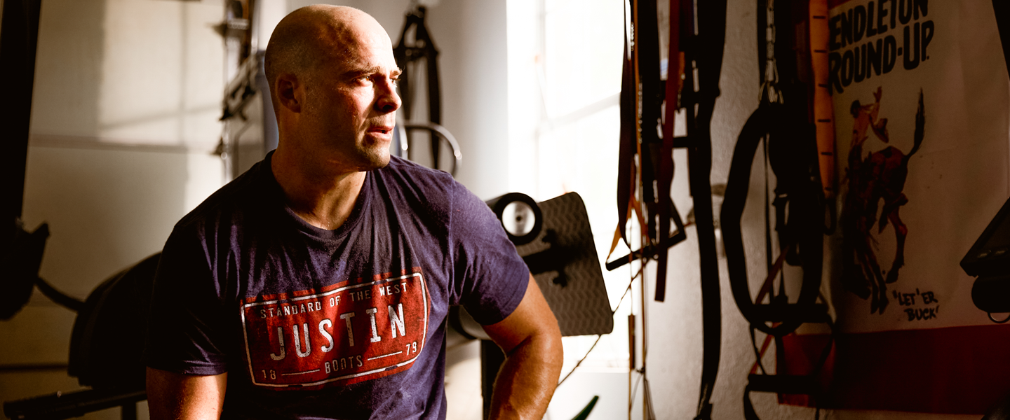 PRCA Bullfighter Dusty Tuckness sitting down staring out a window after a hard work out.